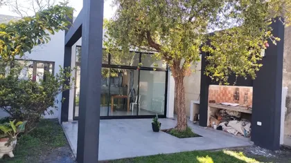 Patio moderno con pérgola negra y árbol grande — proyecto Casa zABALA, por Sep Arquitectura , en La Plata